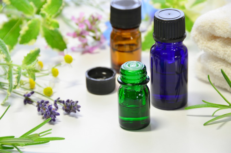 essential oil bottles with plants and flowers